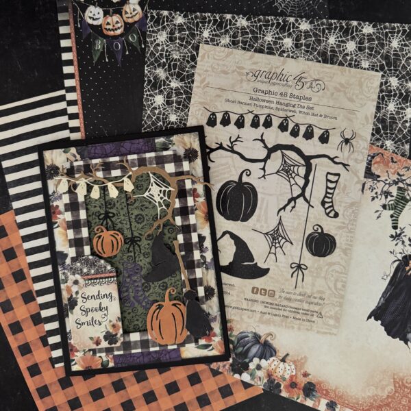 A Halloween-themed scrapbook or card design layout featuring a black-and-white gingham card with orange pumpkins, spiderwebs, a witch hat, and the phrase 'Sending Spooky Smiles,' alongside a larger beige stamped sheet with black Halloween illustrations and patterned paper backgrounds.