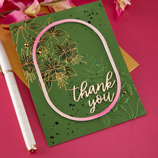 Green card with fuchsia floral design and 'thank you' text on a pink background