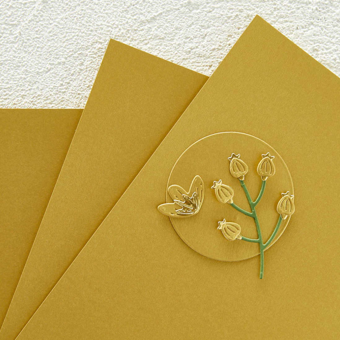 Gold cardstock with a floral design on textured beige paper