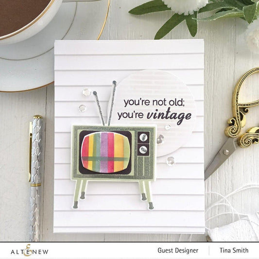 Card with vintage TV design and text 'you're not old, you're vintage' on a decorative background with a cup, pen, and scissors.