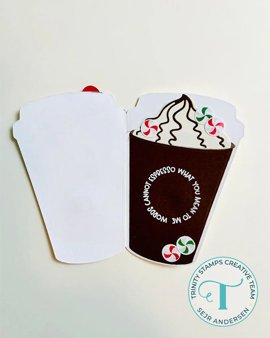 A handmade paper craft or card featuring a brown coffee cup with whipped cream, candy canes, and the words 'I PROPOSE WHAT YOU MEAN TO ME WORDS I CAN'T TELL YOU', shown against a plain light background with a watermark in the corner.