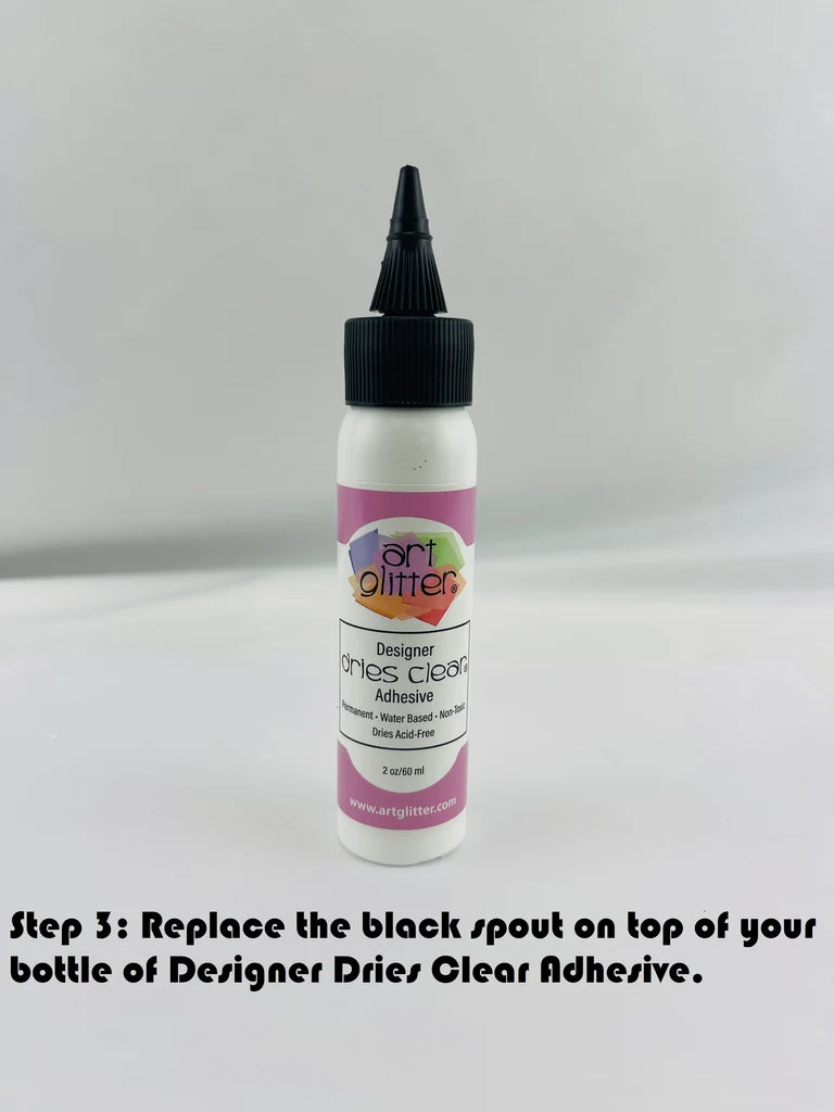 Bottle of Designer Dries Clear Adhesive with black spout on a gray background step 3 of tip application