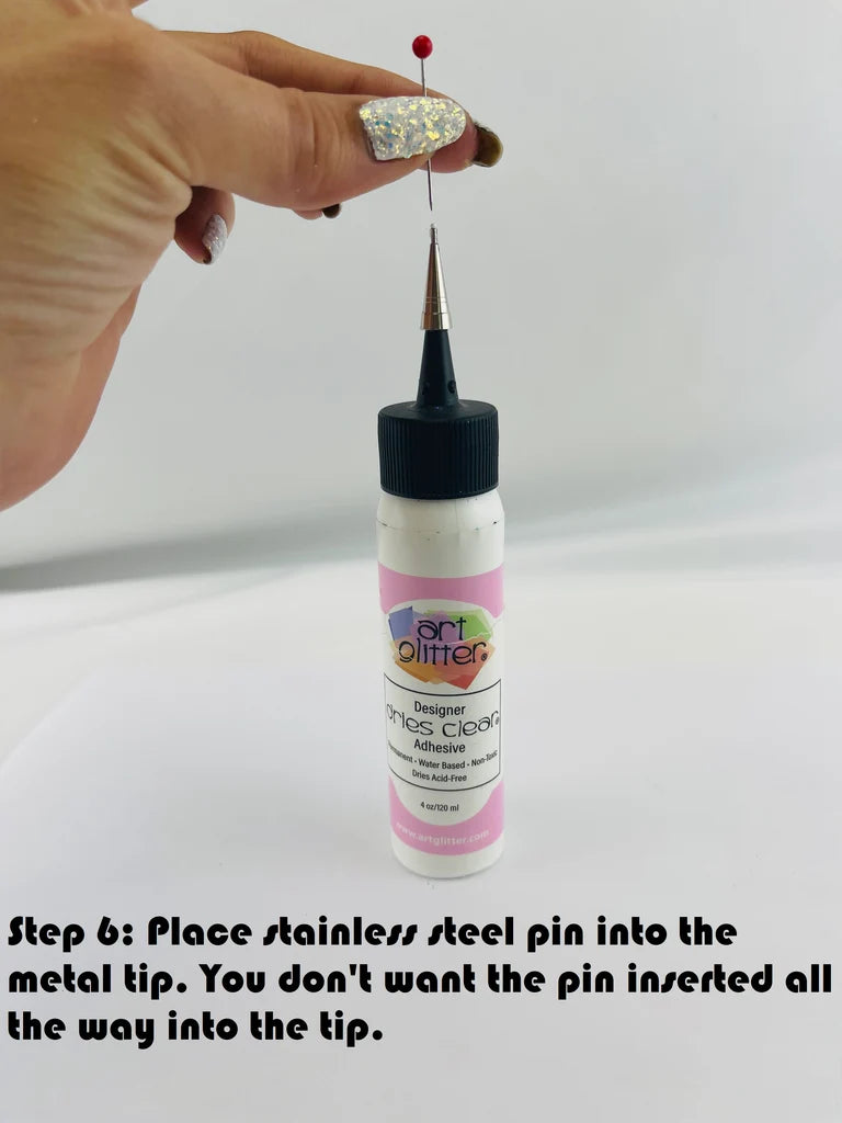 Bottle of glitter with a metal tip and stainless steel pin, on a white background.