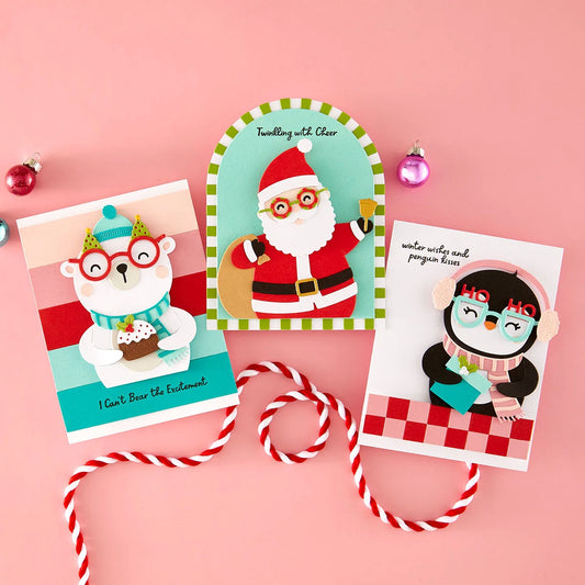 Three Christmas-themed greeting cards featuring a polar bear, Santa Claus, and penguin on a pink background.
