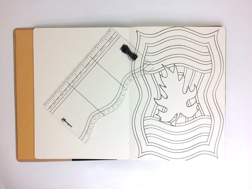 An open notebook or journal on a white background, showing a clear acrylic planner insert with printed lines and a black elastic closure. The right page has black line art illustrations.