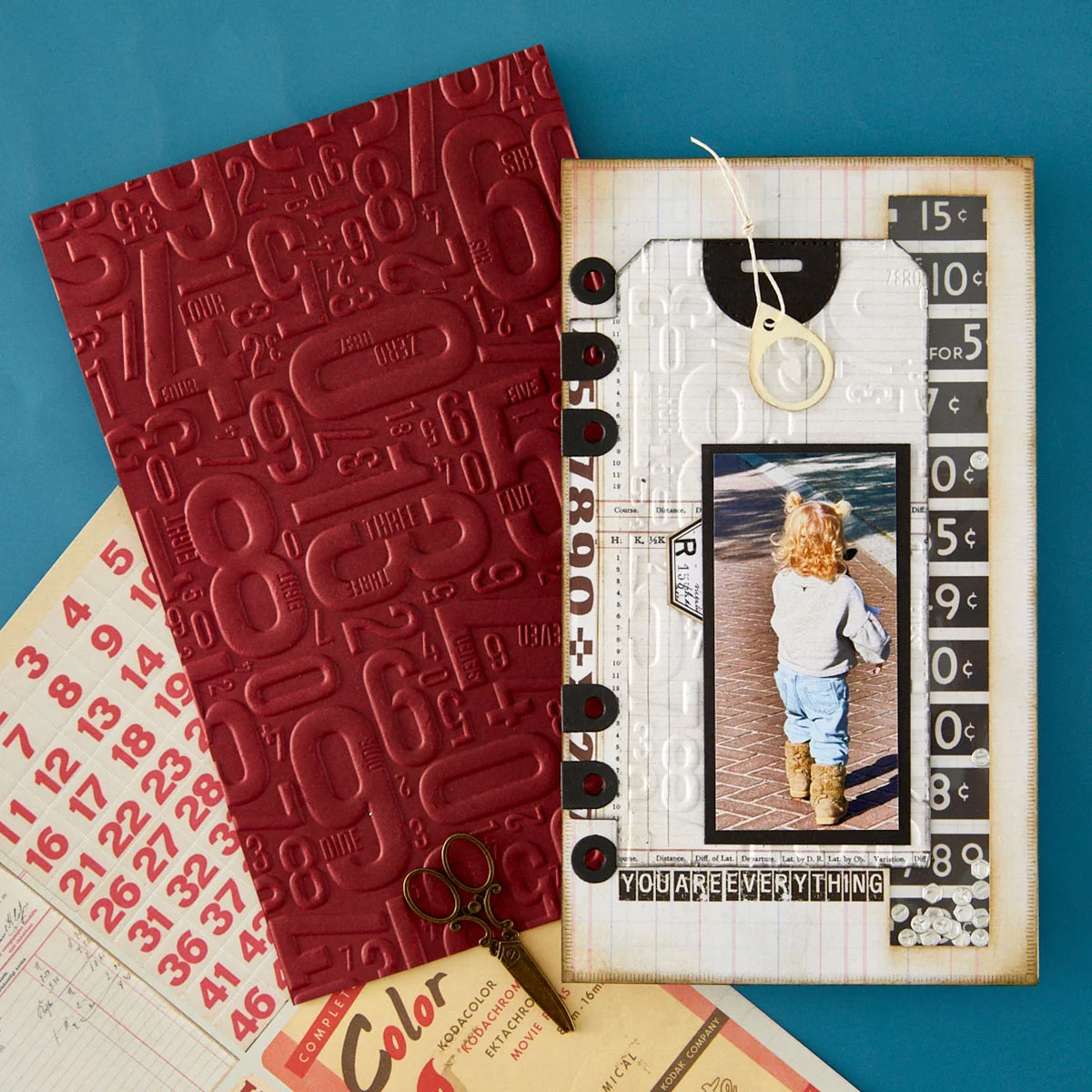 Red embossed notebook and decorative card with photo on a blue background