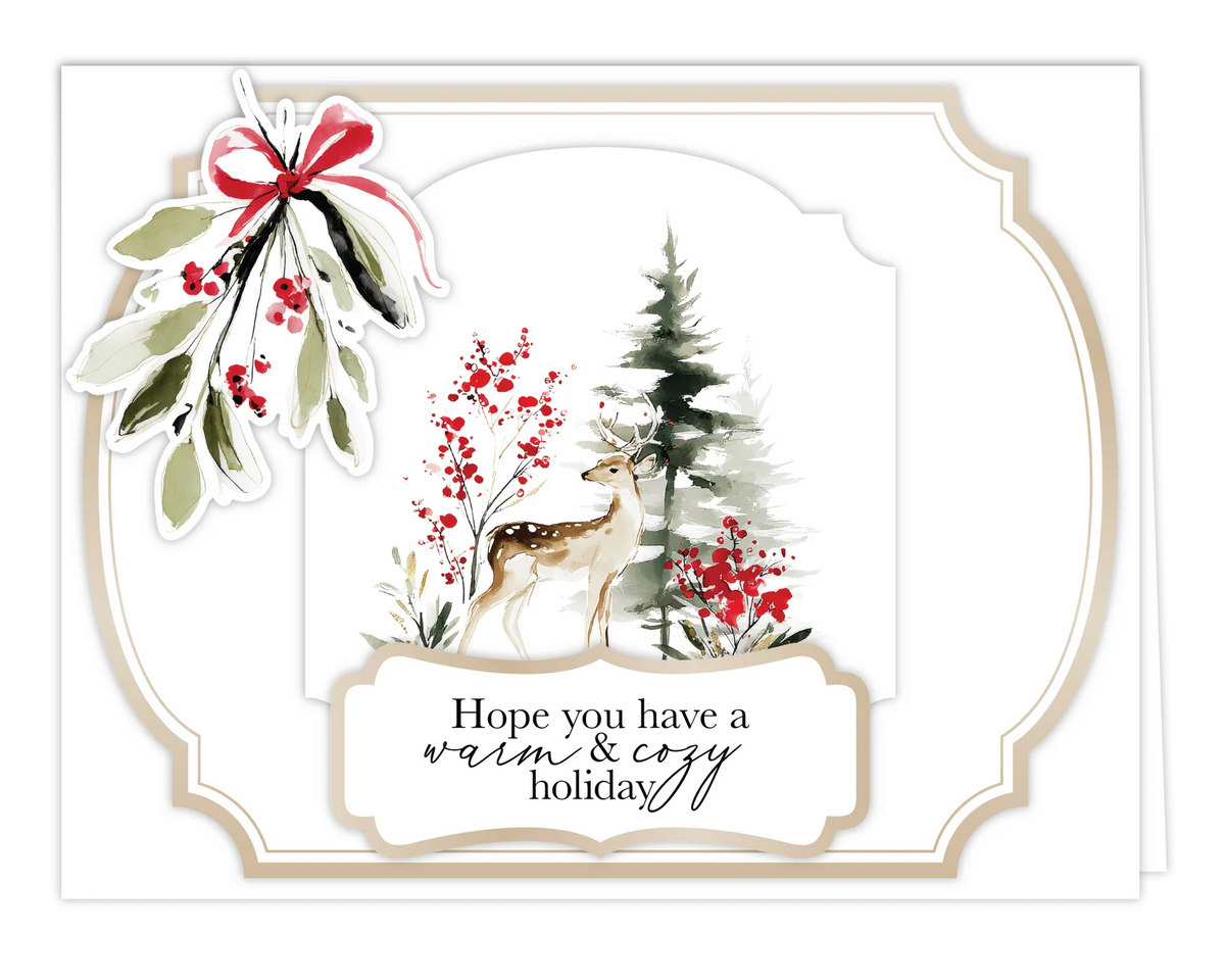 A holiday greeting card with an off-white scalloped border, featuring a watercolor winter scene with a deer, mistletoe, red berries, and a pine tree. The card reads, 'Hope you have a warm & cozy holiday.