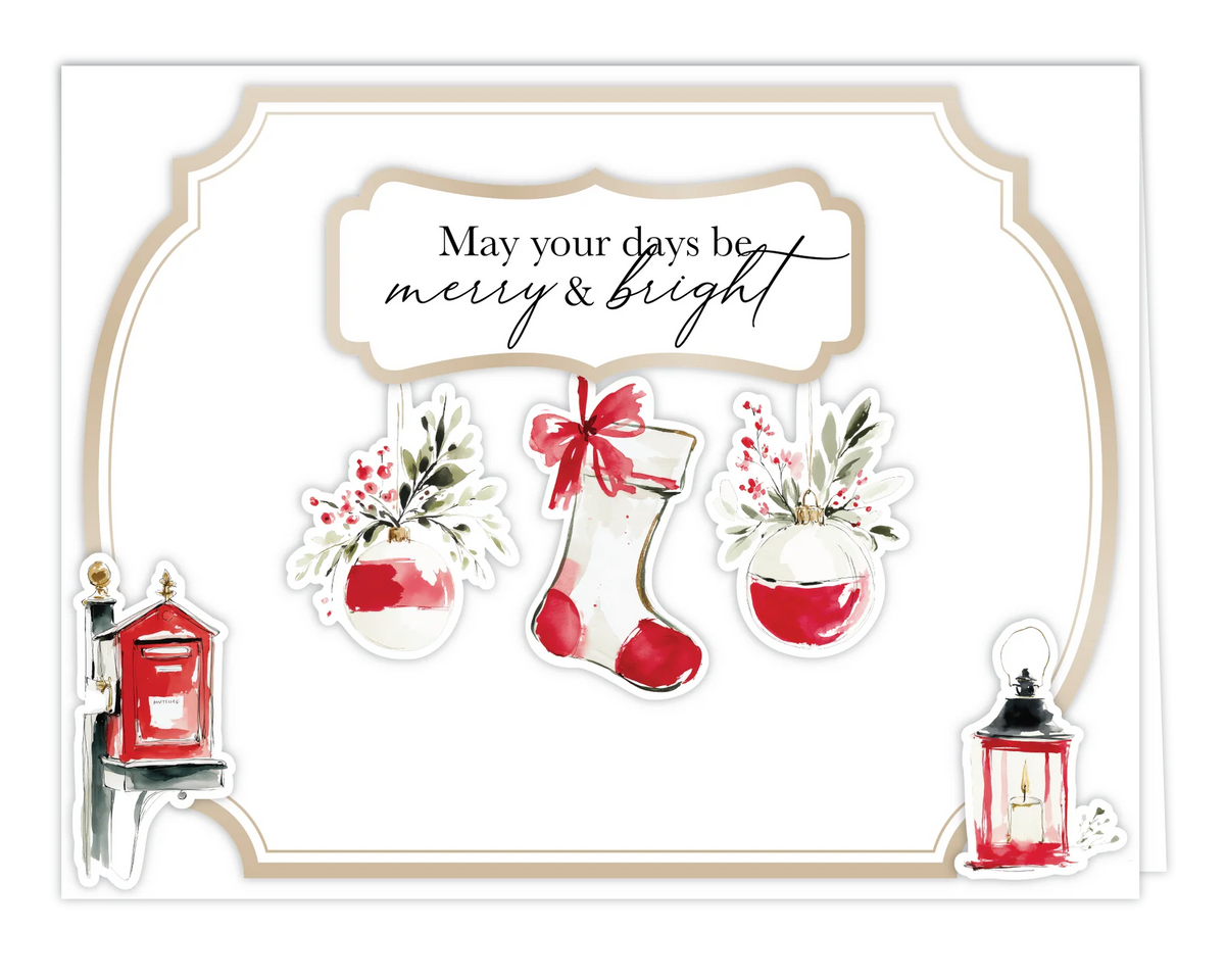 A festive holiday greeting card with the text 'May your days be merry & bright' in black script inside a cream label. The card features watercolor-style illustrations of a red-and-white Christmas stocking with a red bow, two red-and-white hanging vases with green leaves and berries, a small red mailbox on the left, and a red lantern on the right, all framed by a beige double-line border on a white cardstock background.