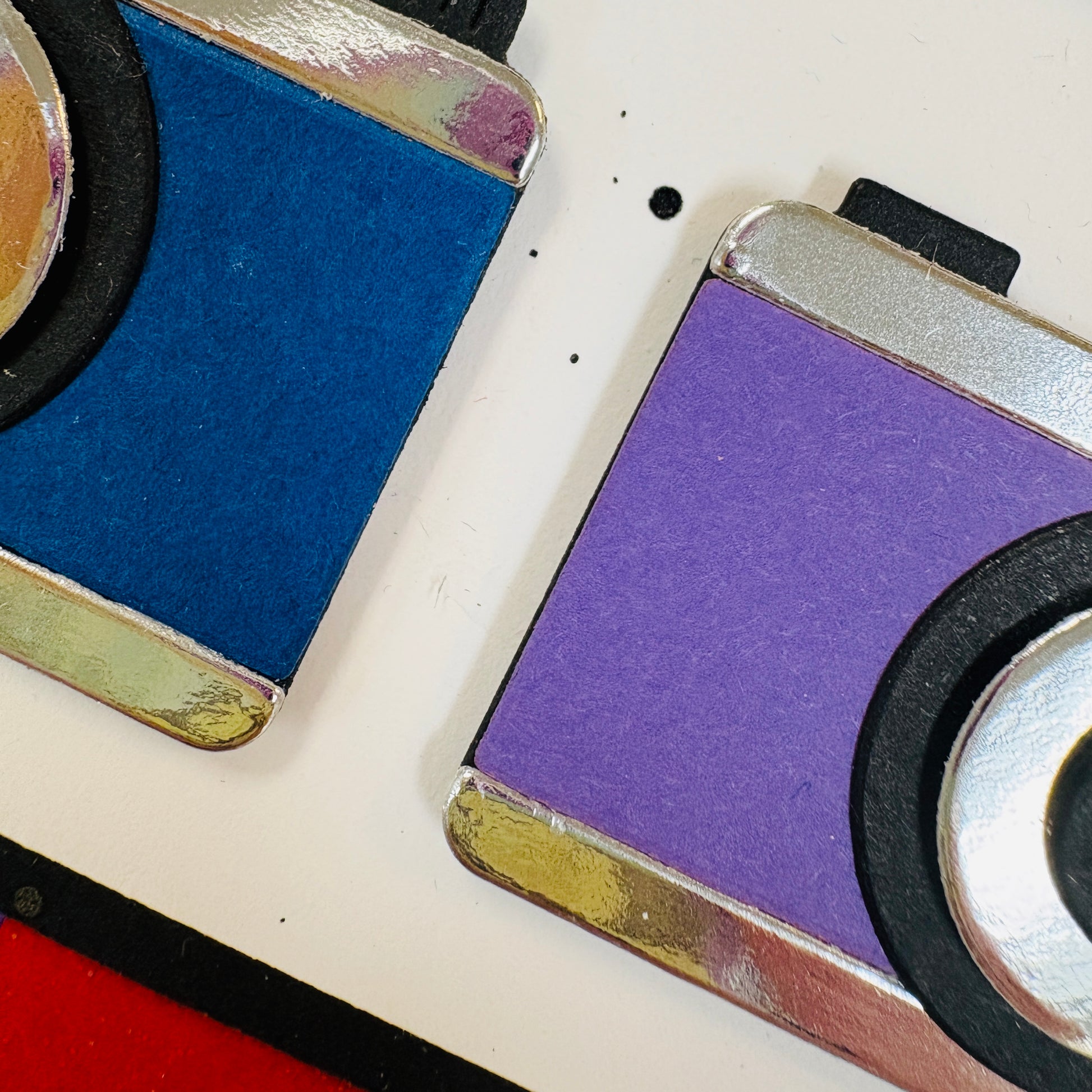 upclose image of purple and blue cameras made from paper piecing