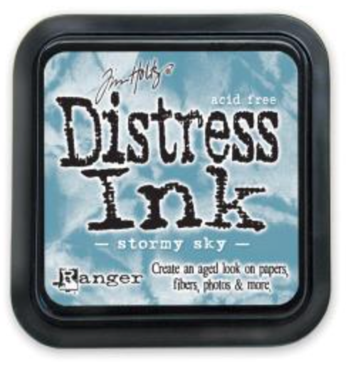 Distress Ink pad by Ranger with 'stormy sky' color on a blue background