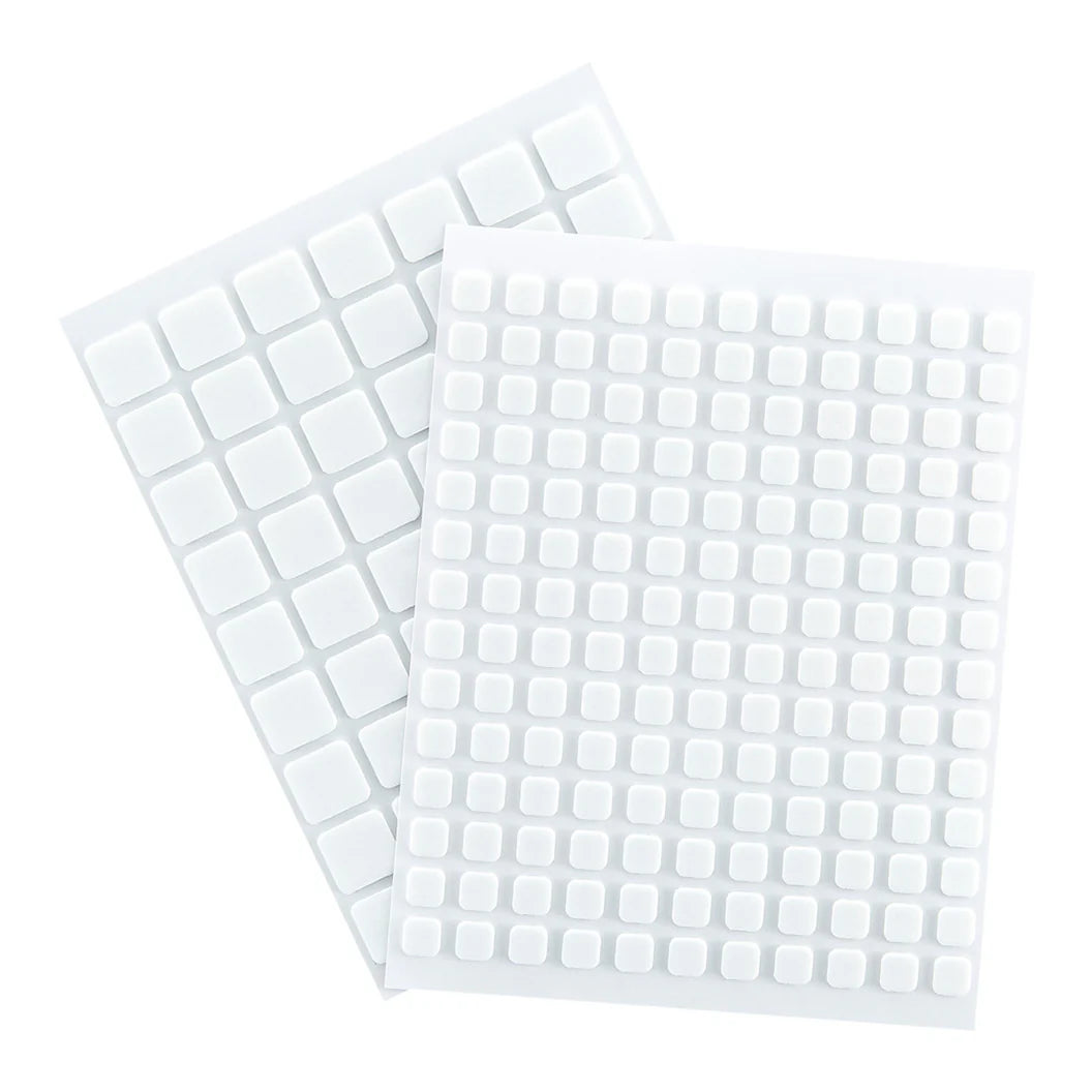Two sheets of white square stickers on a white background