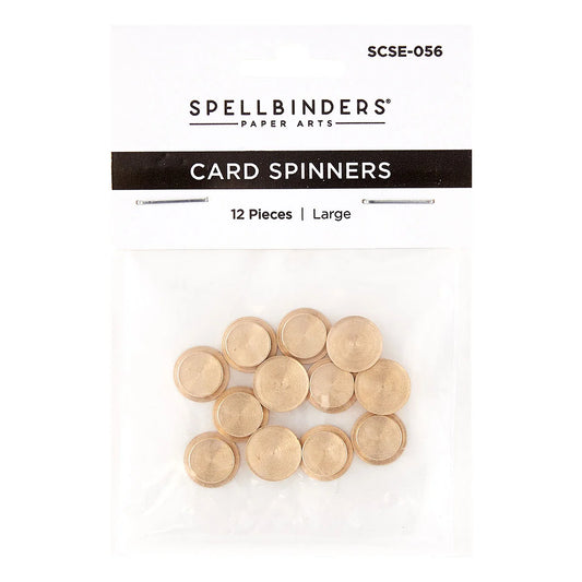 Spellbinders Paper Arts Card Spinners in a clear plastic bag with a white header card. The package contains 12 large gold-colored circular card spinners, and the header card displays the product code SCSE-056 and the Spellbinders brand name.