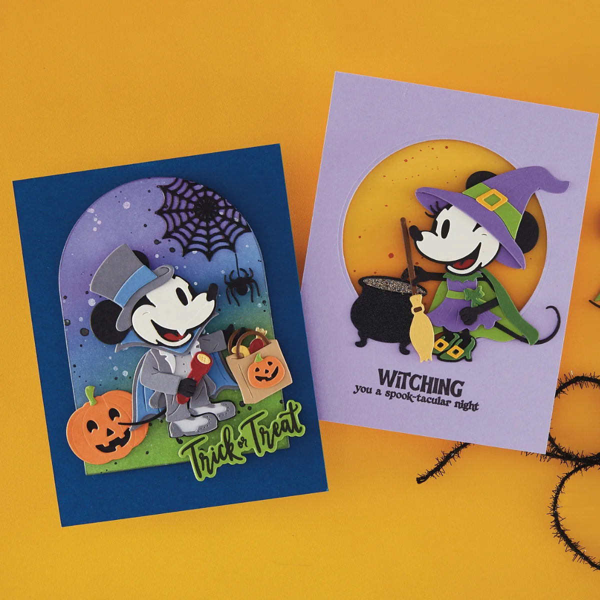 Two Halloween-themed greeting cards displayed on a bright yellow background. One card features Mickey Mouse dressed as a wizard holding a pumpkin bag, with a purple night-sky arch and the words 'Trick or Treat.