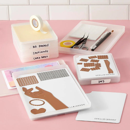 Spellbinders jewelry making kit with various components including a hand-shaped mold, metal mesh, adhesive patches, tweezers, and storage containers on a pink surface.