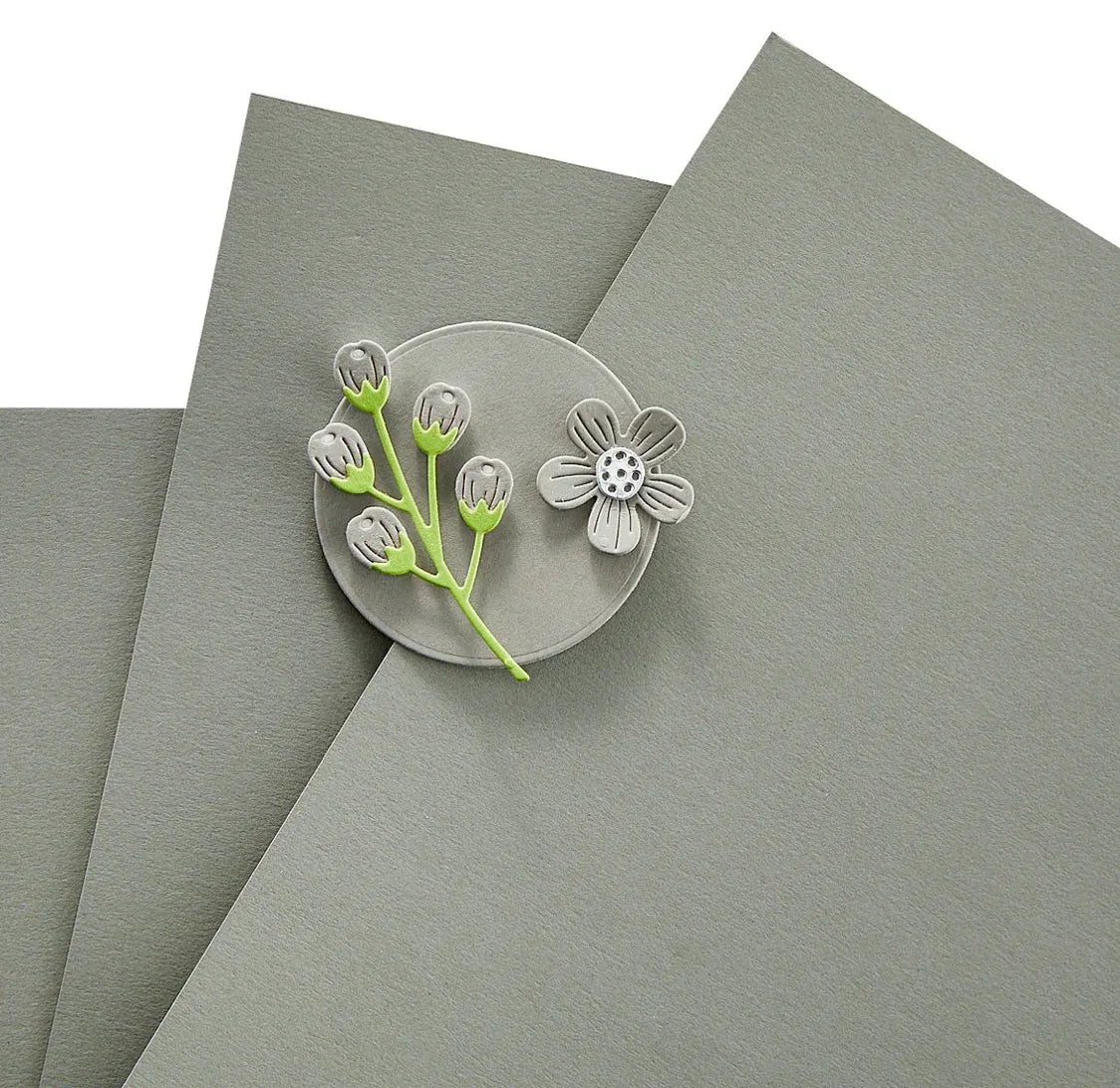 Clear decorative pin with floral design on a gray surface