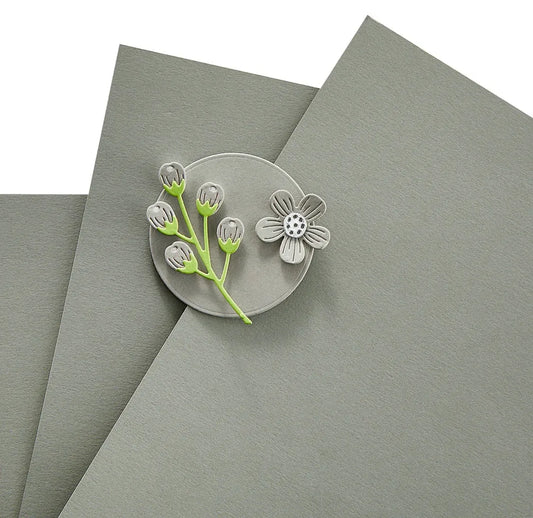 Clear decorative pin with floral design on a gray surface
