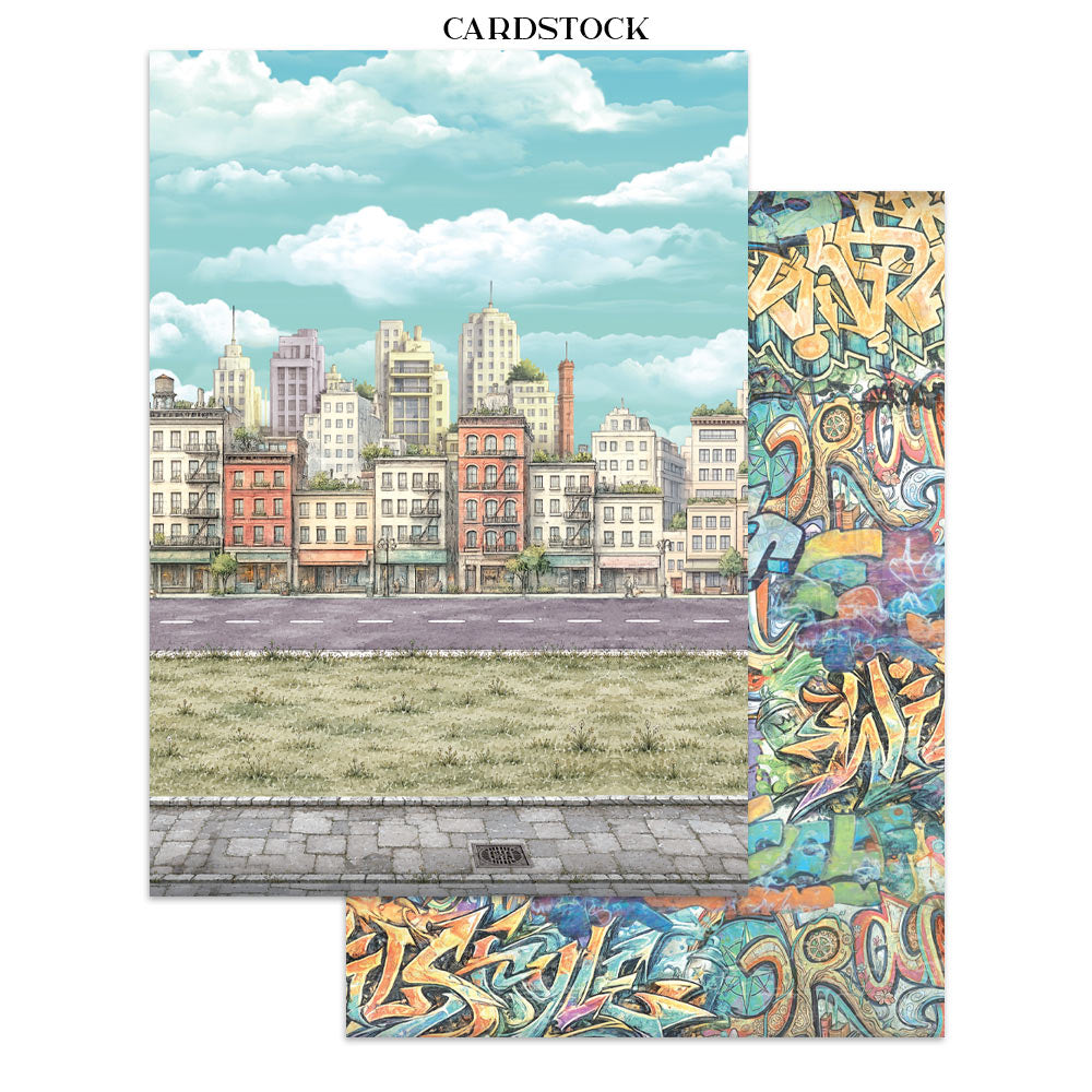 two sheets of cardstock featuring a cityscape illustration with a street, grassy field, buildings, and a blue sky with clouds. A vertical strip on the right shows colorful graffiti-style artwork, and a smaller matching strip is shown below.
