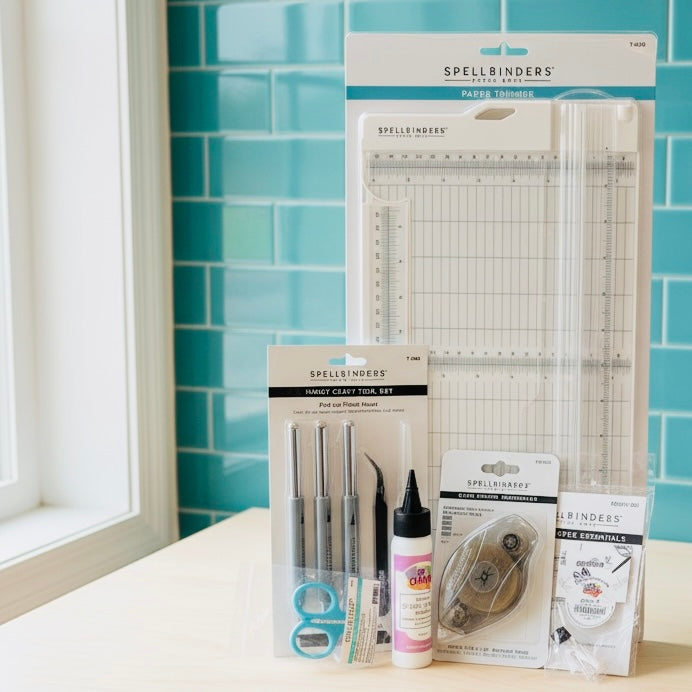 Spellbinders craft tools and supplies on a table with a blue tiled wall background