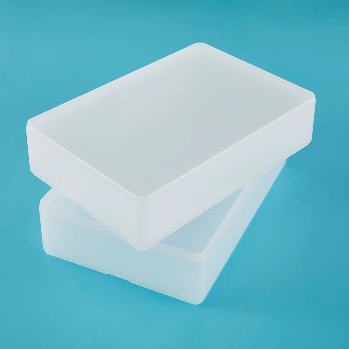 Two translucent white plastic storage boxes stacked slightly offset on a solid light blue background.