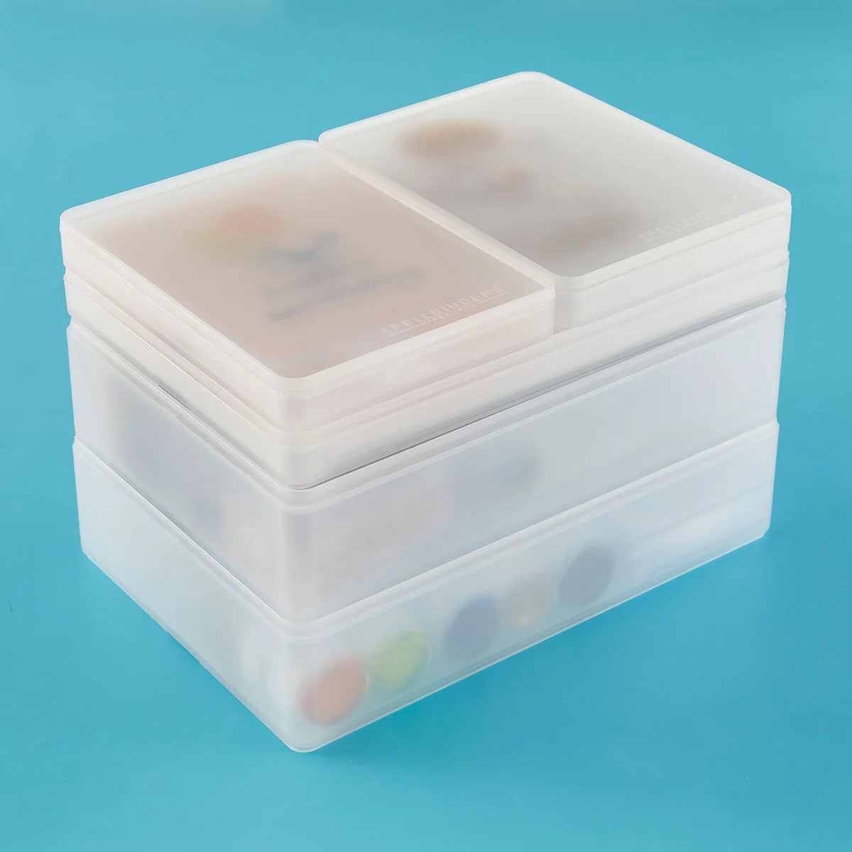 Stack of clear plastic containers with compartments on a blue background