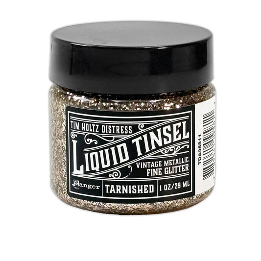 A jar of Ranger Tim Holtz Distress Liquid Tinsel Fine Glitter in the 'Tarnished' shade, featuring a black lid and a black-and-white label, set against a plain white background.