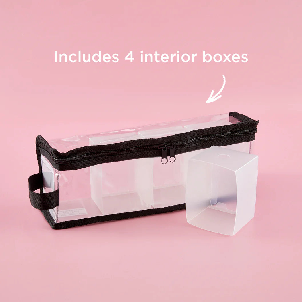 Clear makeup bag with black zipper on a pink background, labeled 'Includes 4 interior boxes'.