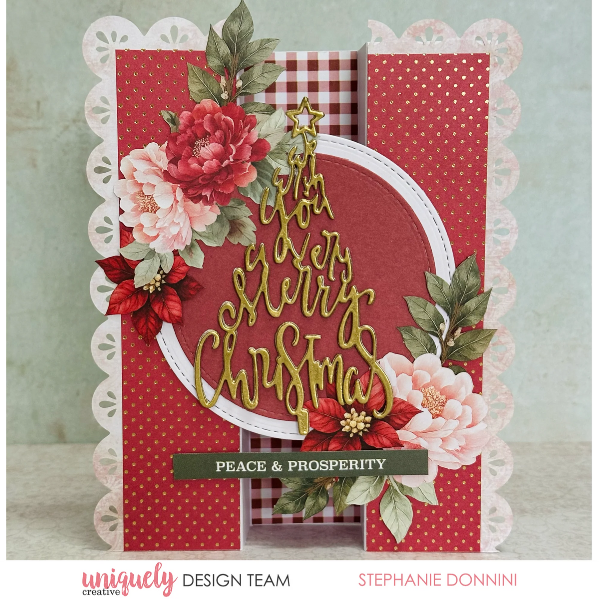 hand made card with pretty pink and red flowers with leaves, a gold tree shaped wih you a very merry Christmas sentiment in a triange shape on a red paper panel with white polka dots.